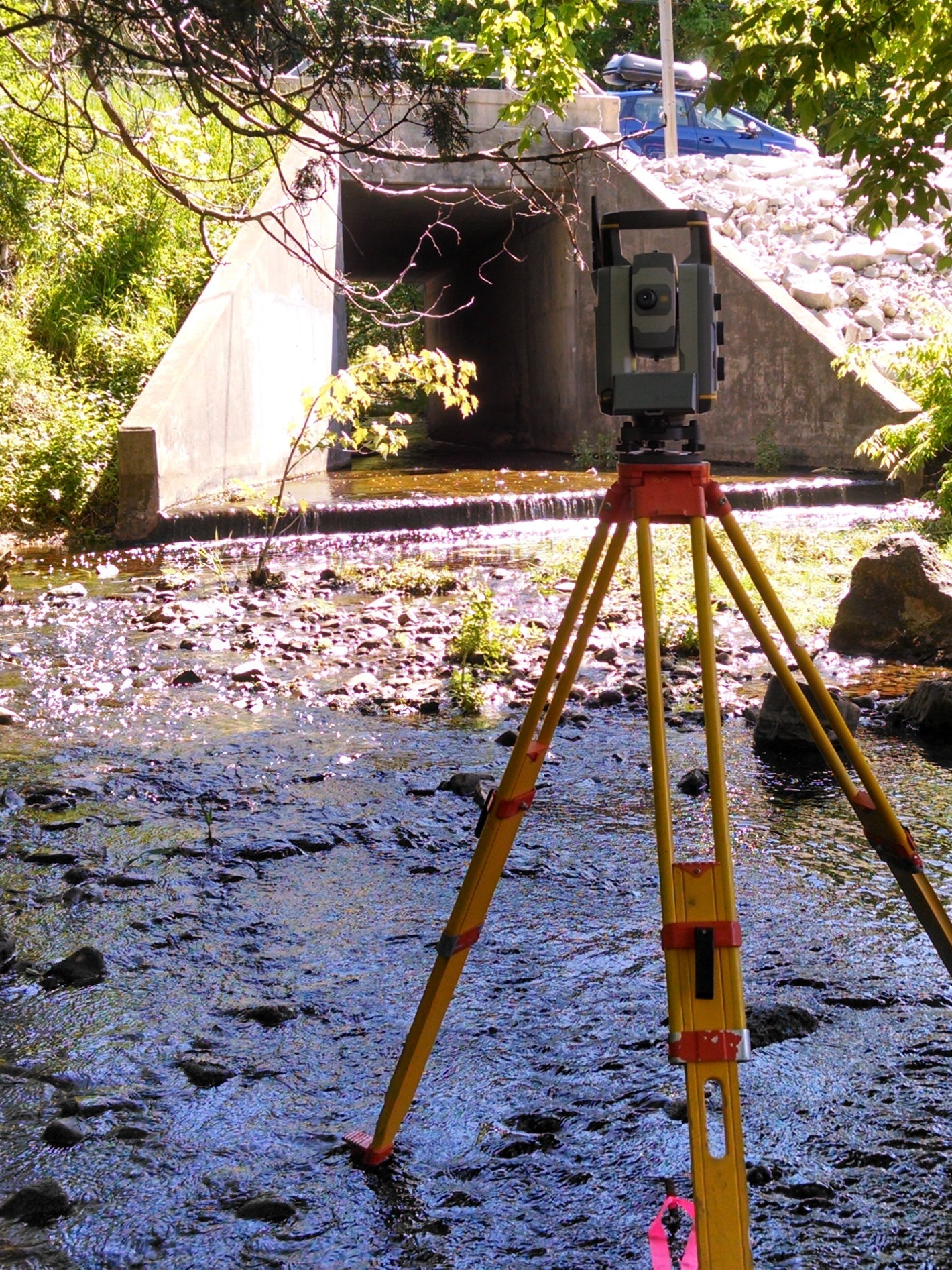 Total station surveying equipment in creek Total station surveying equipment in creek
